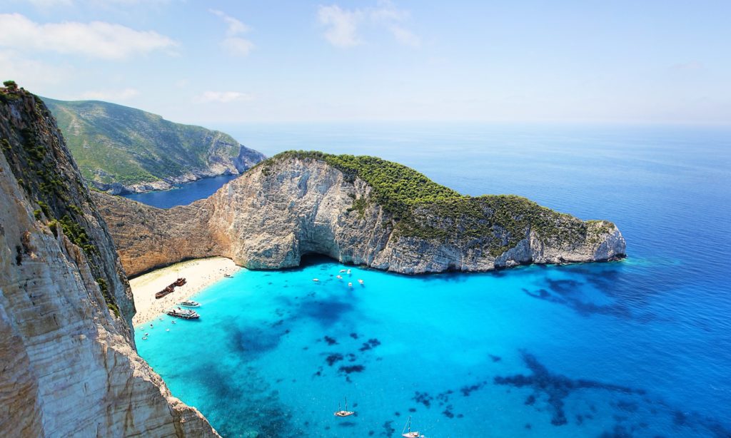 Aerial view of bright blue waters and green mountains